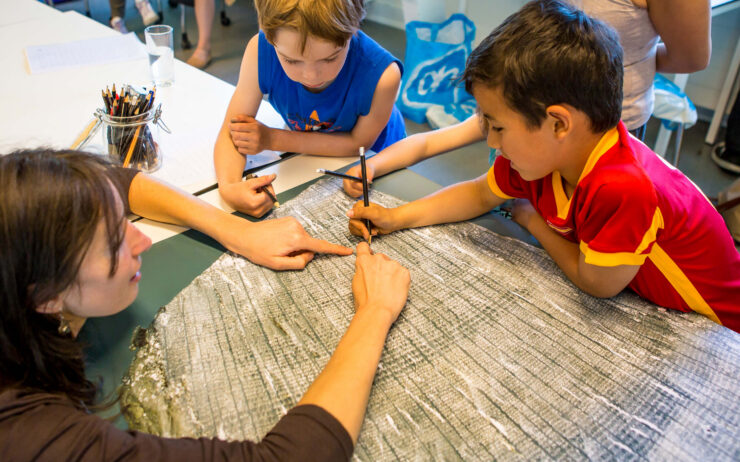 Kinderen die jaarringen van een boom aan het tellen zijn.