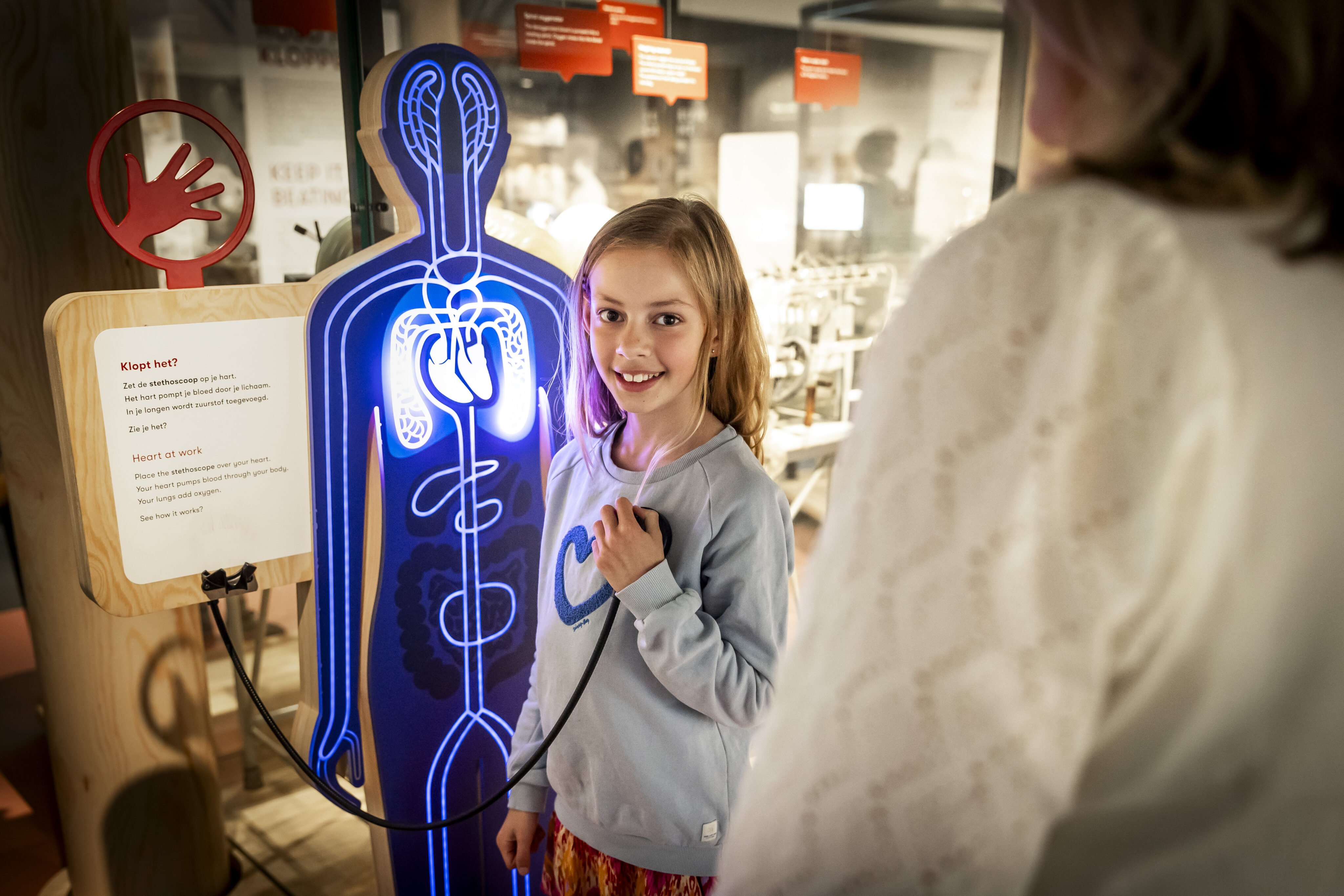 Kind meet met een stethoscoop haar hartslag in de tentoonstelling